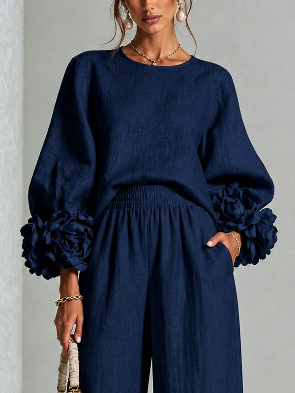 María | Top azul marino con llamativos puños florales, combinado con un traje de pantalón de corte ancho